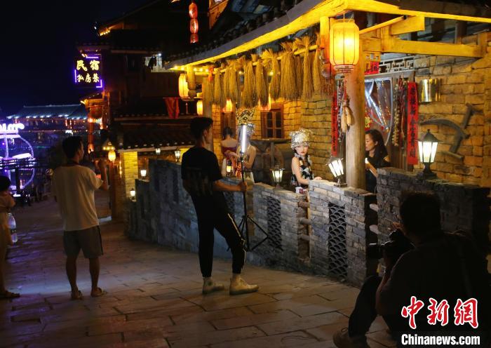 在梦呜苗寨内，随处可见市民打卡体验苗族风情。　蒙鸣明 摄