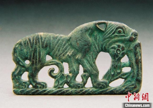 虎衔羊纹青铜P形饰牌(战国)。　三星堆博物馆供图