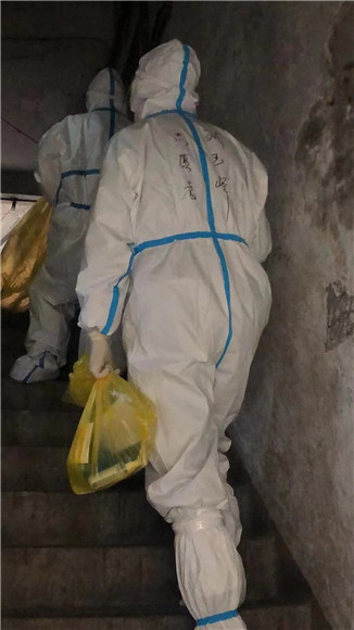 红岩志愿者爬楼梯为居民送物资。沙坪坝街道办事处供图 华龙网发