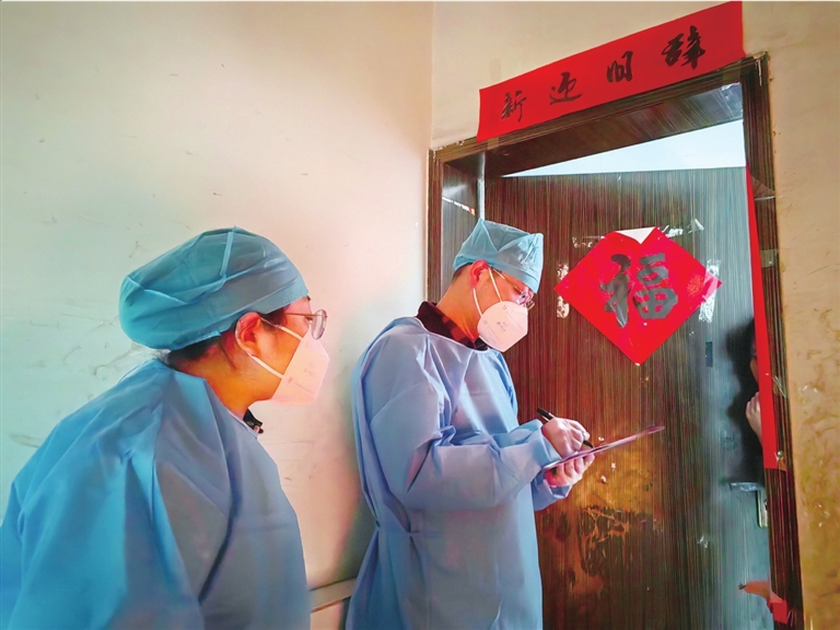 王家街道组织工作人员“敲门”入户排查核酸检测情况。通讯员 杨荟琳 摄