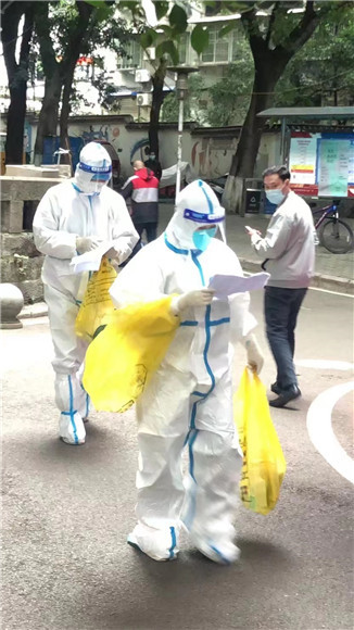 红岩志愿者化身大白，一手提物资，一手核对清单。沙坪坝街道办事处供图 华龙网发