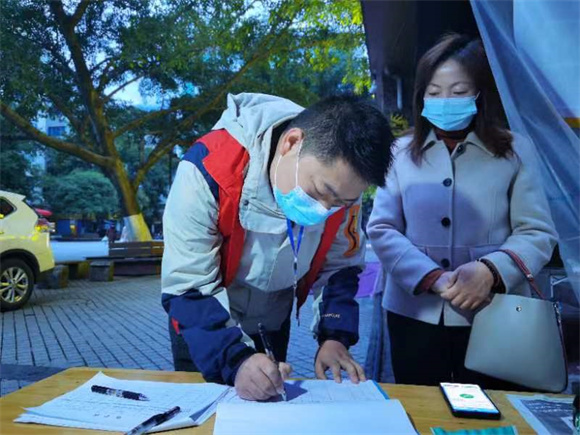 15日清晨，陈永建在认真为过往市民登记。特约通讯员 李美华 摄