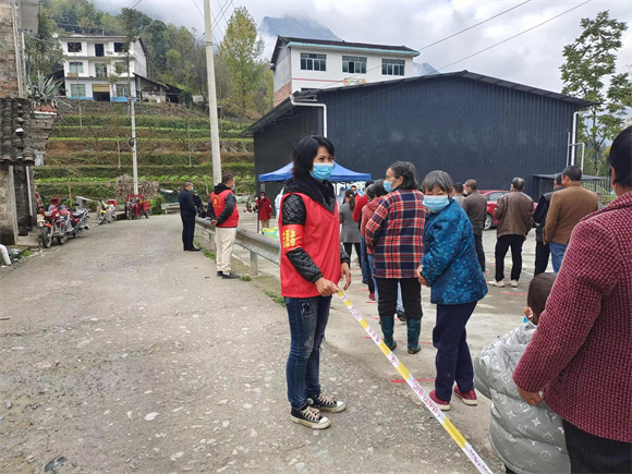 区杏梅在核酸采样点维护秩序。巫溪县人大常委会办公室供图 华龙网发