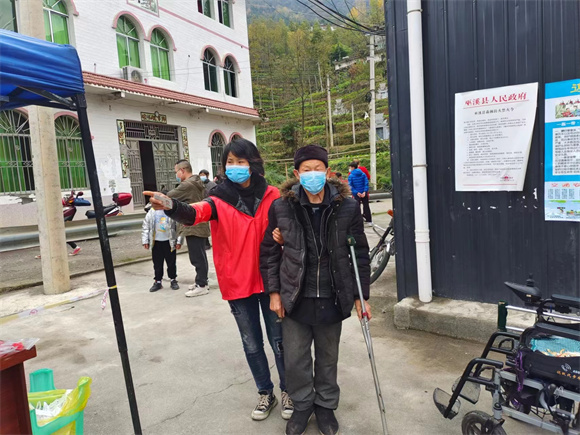 区杏梅搀扶行动不便老人做核酸。巫溪县人大常委会办公室供图  华龙网发