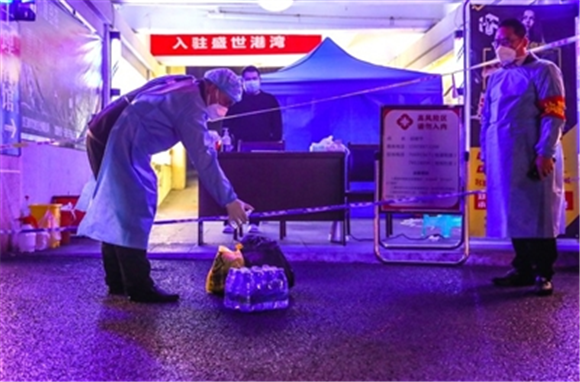 盛世港湾小区值守人员正在为隔离居民生活物资消毒。 通讯员 龚长浩 摄