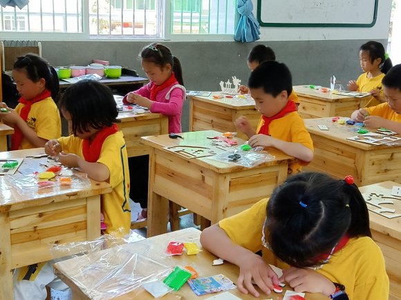 学生们正在认真做剪纸手工（资料图）。通讯员 李麟 摄