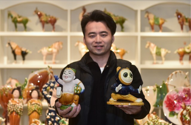 在孟津区朝阳镇南石山村的张家彩窑展示车间，张毅鹏展示自己制作的唐三彩特色文创作品。黄政伟摄
