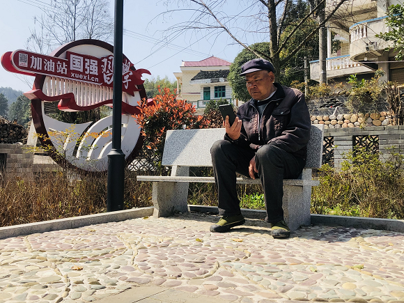 钟灵镇凯堡村村民杨再端正在收听广播。通讯员 杨帆 摄