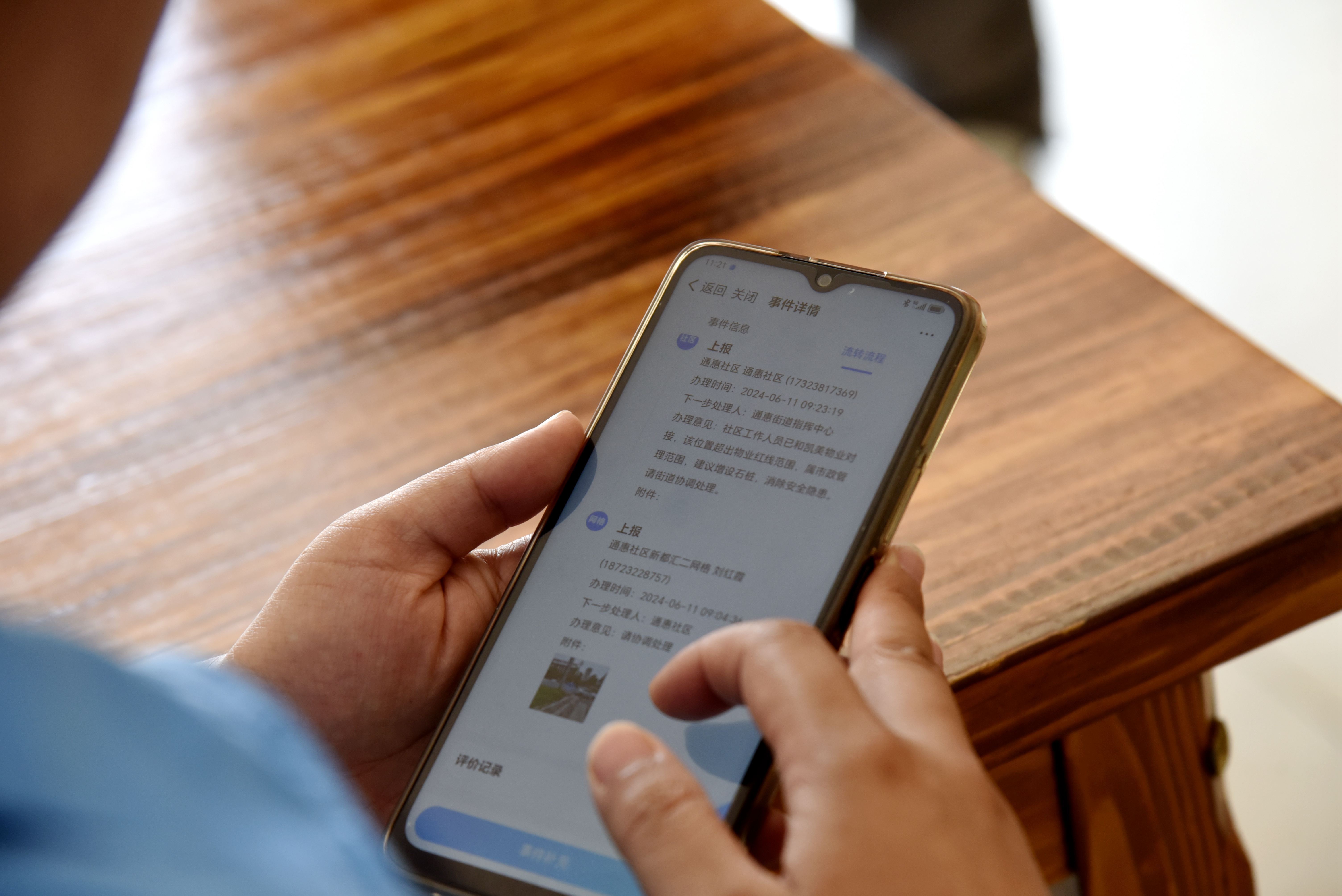 网格员通过手机将发现问题上报到基层智治平台。（张静 摄）