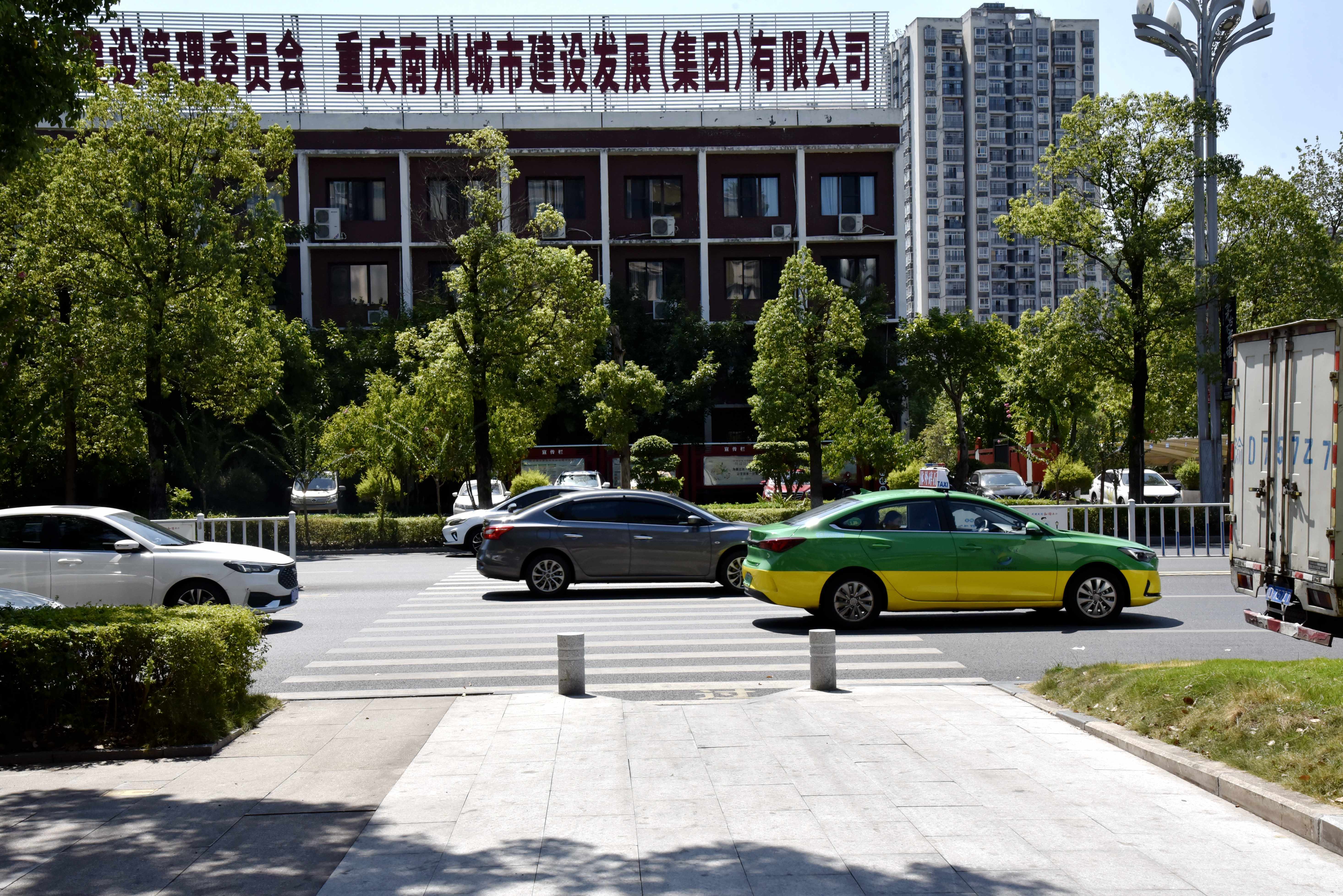 綦江区通惠街道新都汇小区大门口新拓宽的人行道路口。（张静 摄）