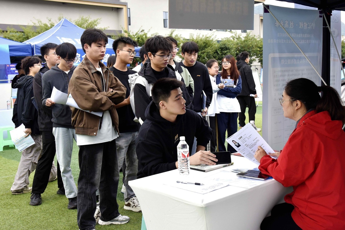 大学生正与招聘企业代表进行交流。（摄影：张静）