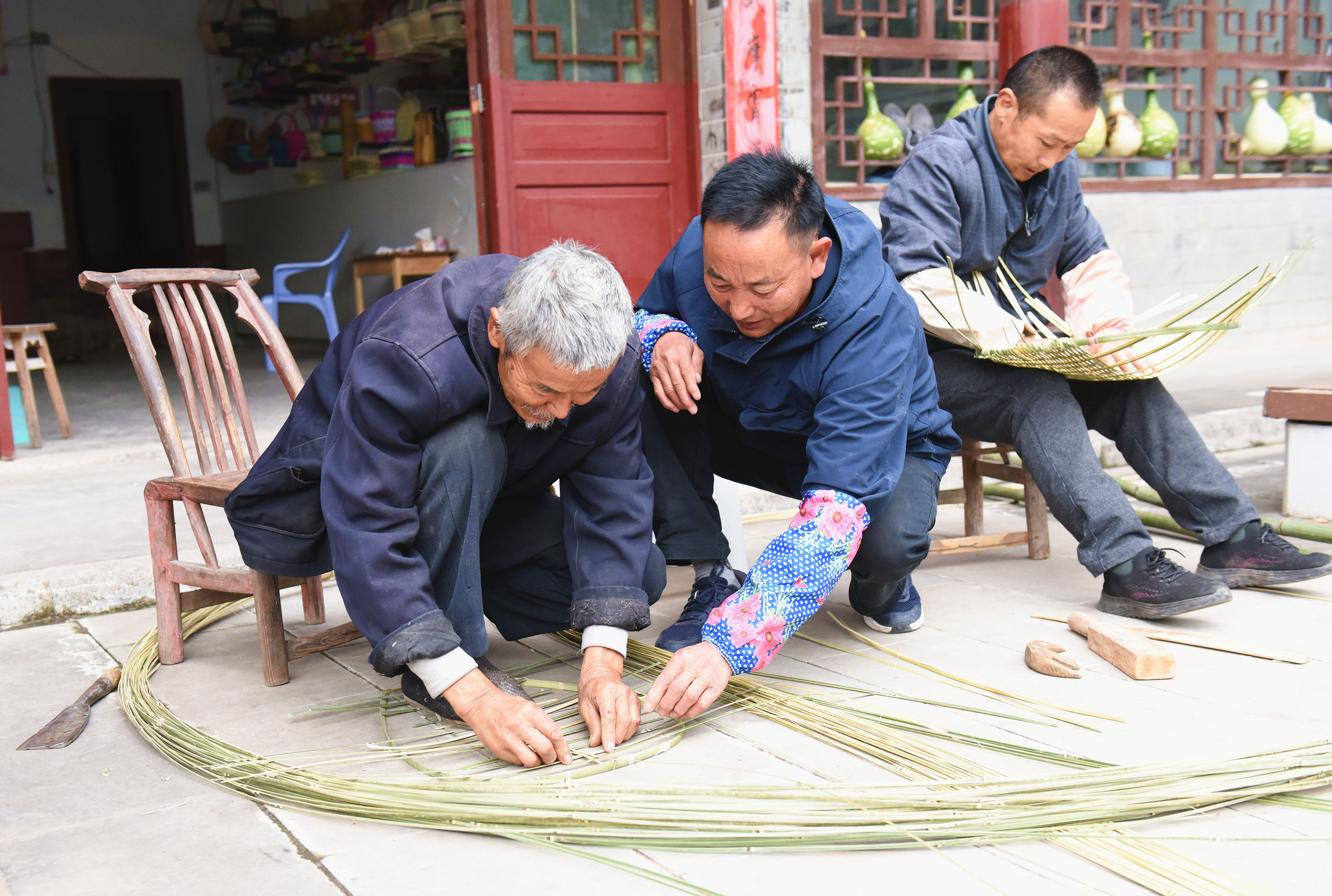 万书华（右）指导当地群众编织竹制品.jpg